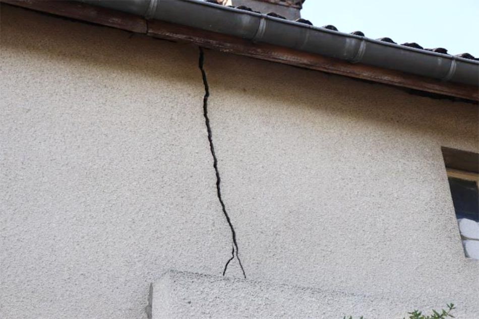 Cracked house wall under roof