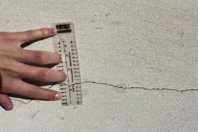 Main tenant une règle mesurant une fissure