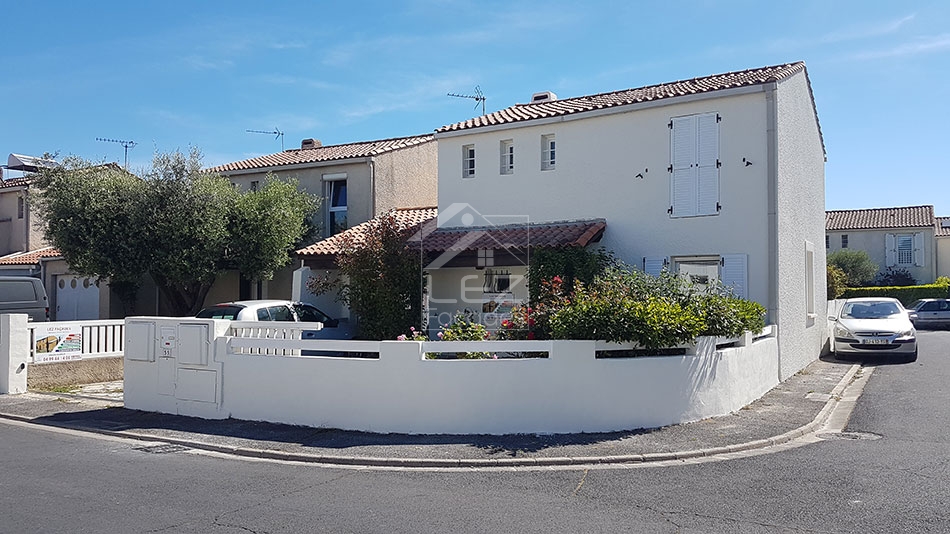 Maison blanche avec jardin et clôture