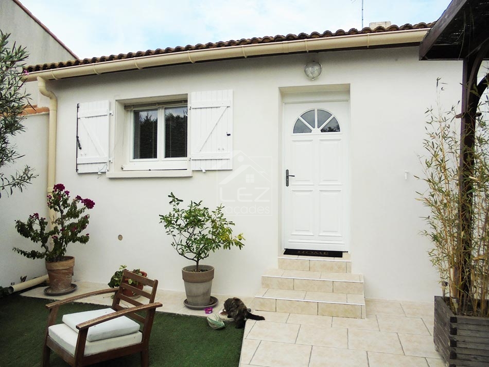Maison blanche avec porte blanche et plantes