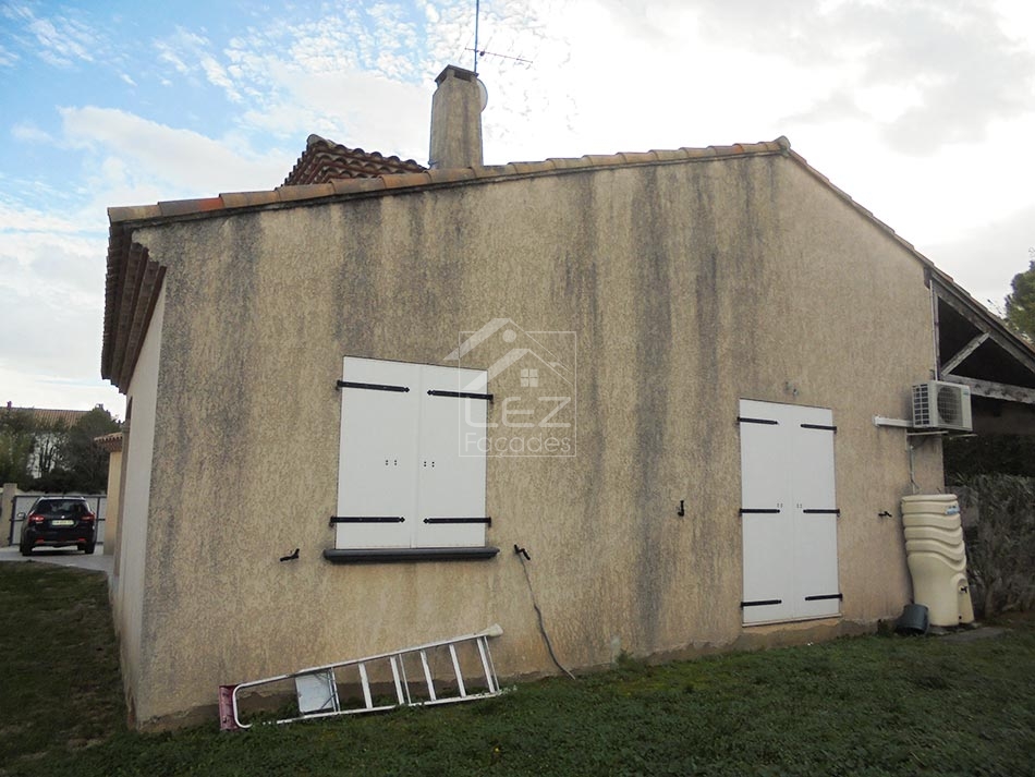 Maison en stuc avec volets blancs et échelle
