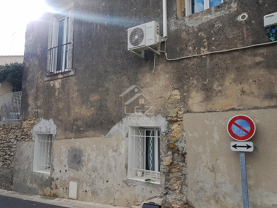 Vieille façade de bâtiment avec climatiseur et panneaux de signalisation