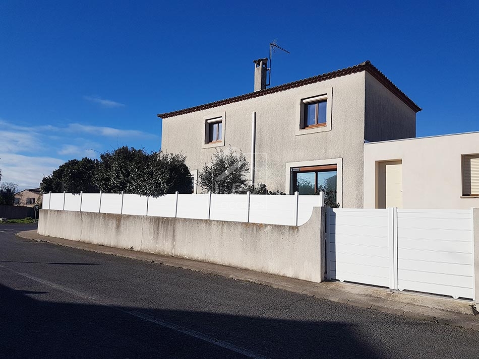 Maison moderne avec clôture blanche et arbres