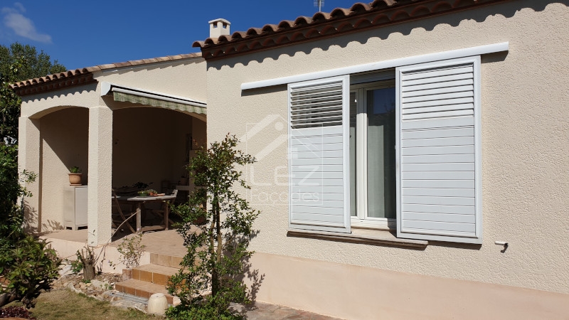 Maison avec volets blancs et patio