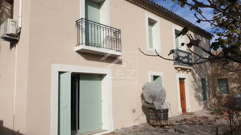 Façade de bâtiment avec balcon et portes vertes