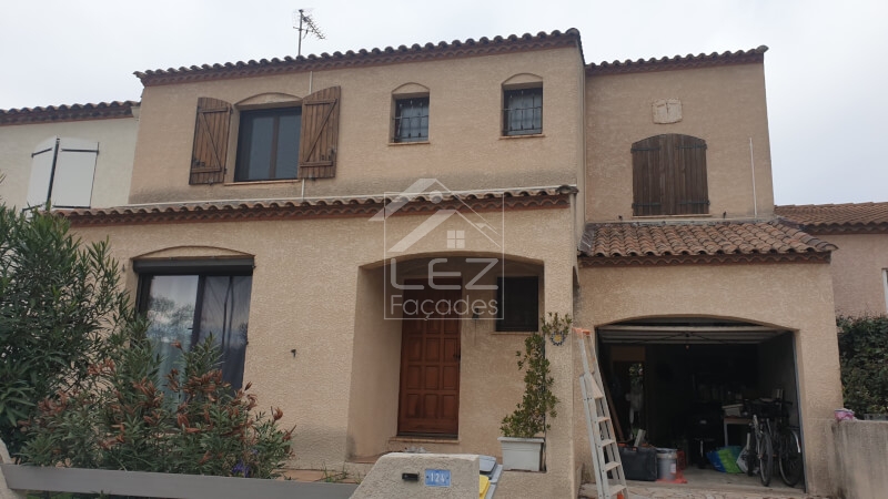 Maison à deux étages avec porte de garage ouverte