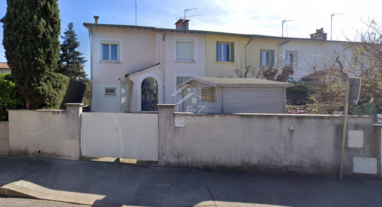 Maison de deux étages avec clôture et portail