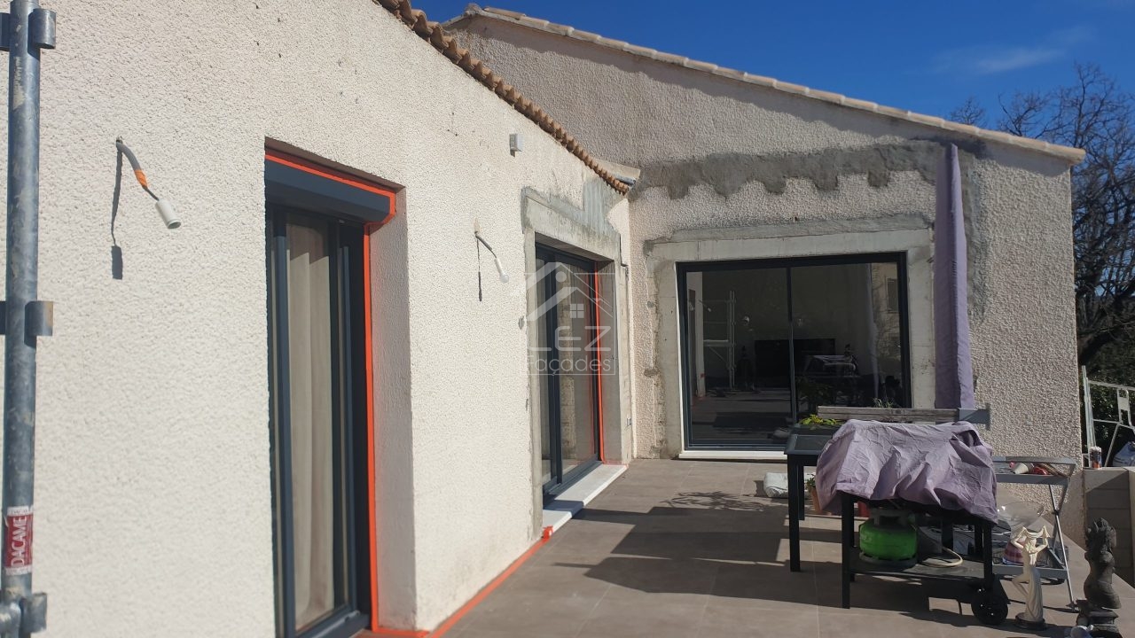 Maison blanche avec portes vitrées et table couverte