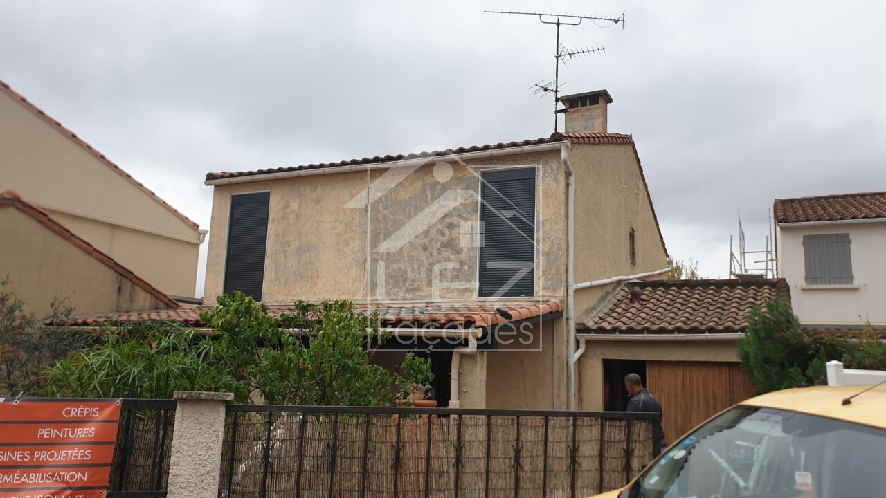 Façade de maison avec fenêtres à volets fermés et toit en tuiles rouges
